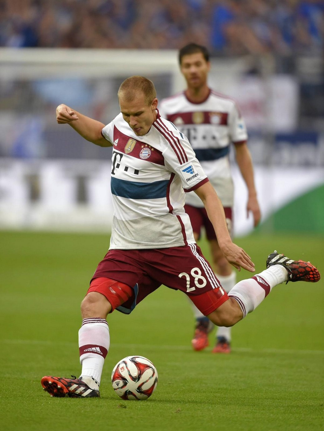 Holger Badstuber in a Bayern Munich away kit striking the ball